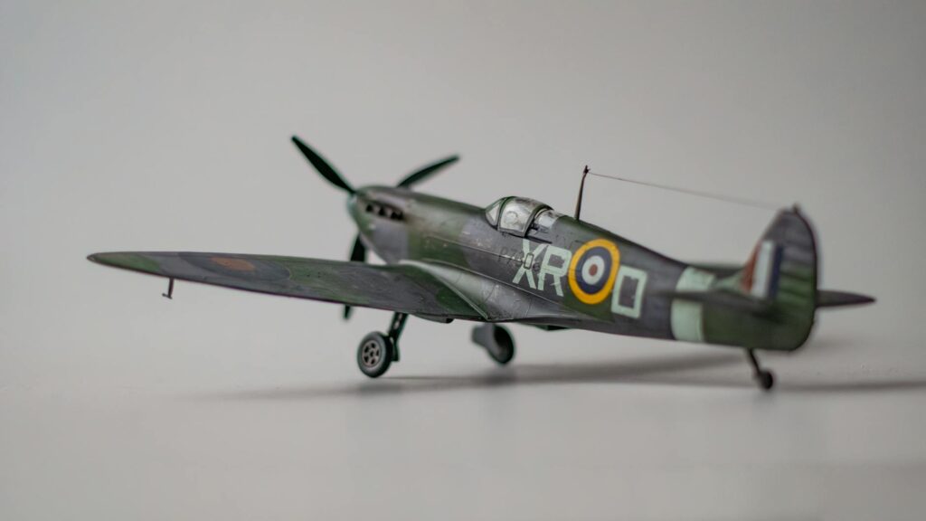 A model of a vintage military aircraft with green camouflage paint and British insignia displayed on its side.