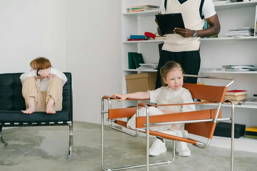 Children engage in a therapy session while the therapist observes.